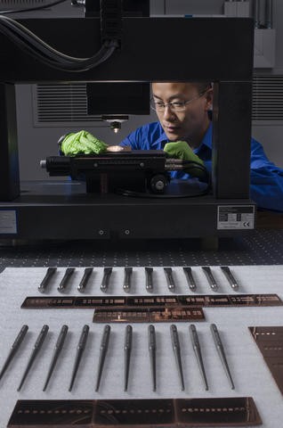 NIST researcher Alan Zheng uses a 3D disc scanning confocal microscope to examine a chisel toolmark