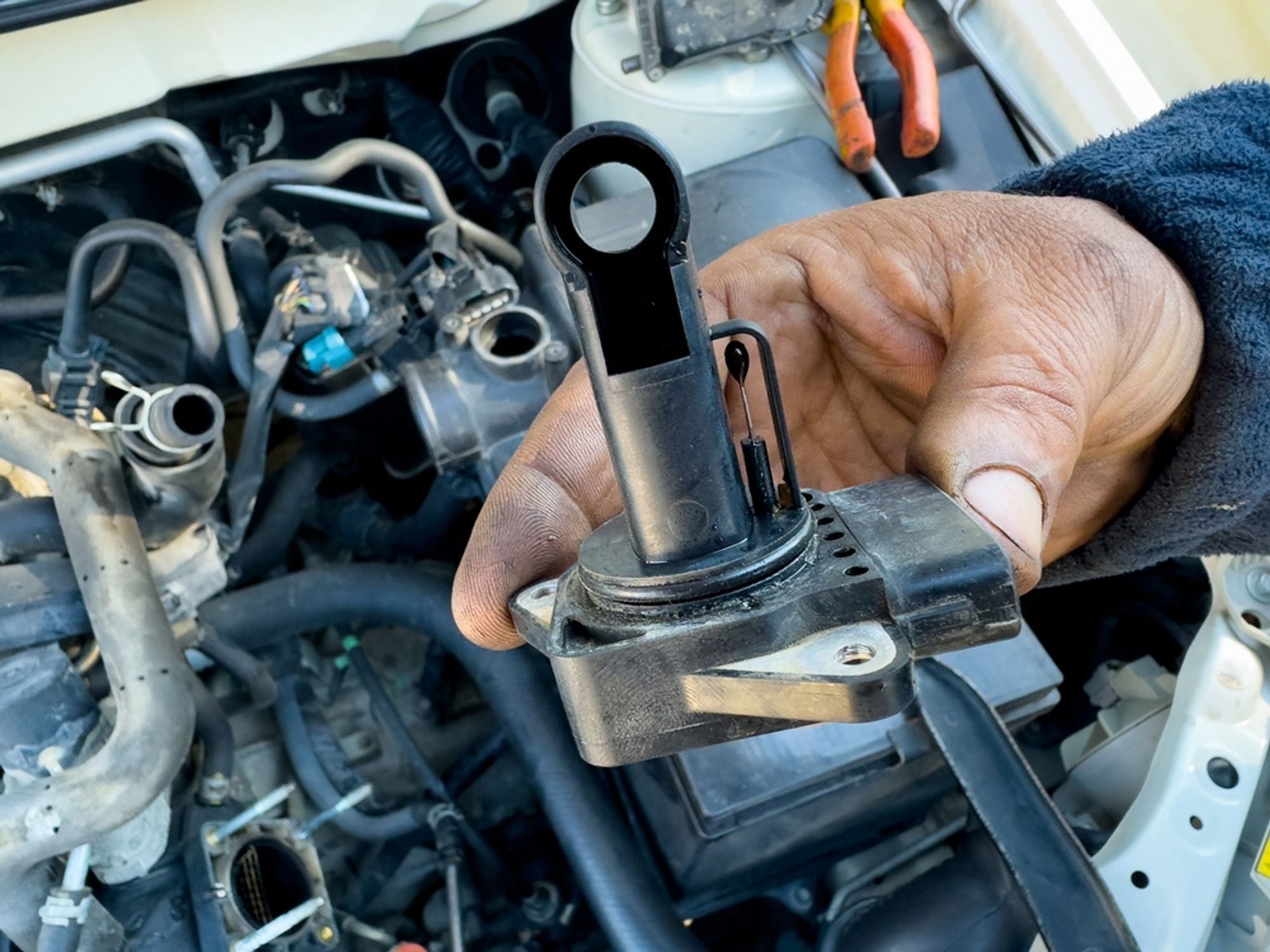 Automotive technician using diagnostic tools to check a faulty MAP sensor, highlighting the process of MAP sensor diagnosis