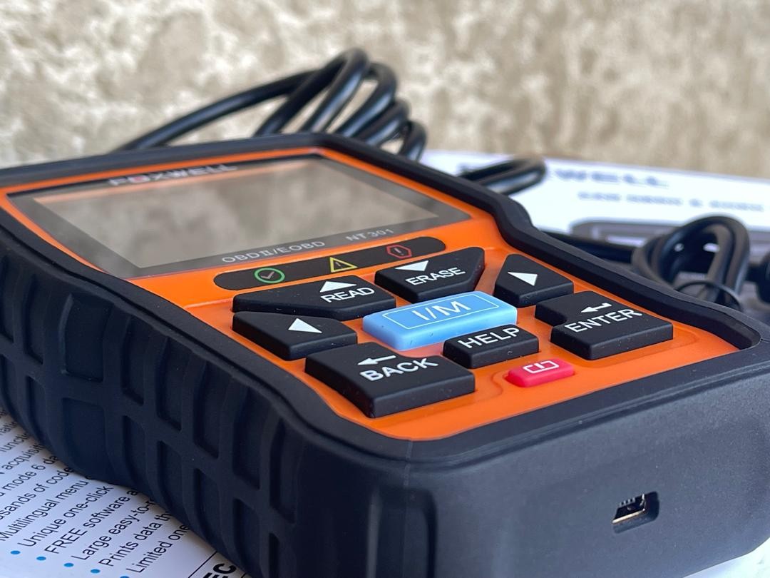 Foxwell NT301 diagnostic scan tool displayed in box, highlighting its features for automotive diagnostics.