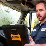 Technician using a laptop to diagnose a truck