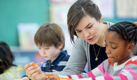 Teacher with students using technology in the classroom